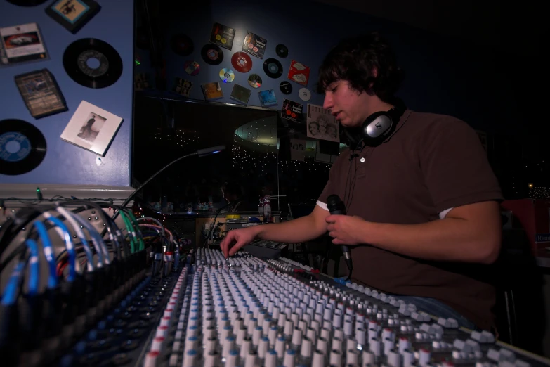 a dj mixing in front of his equipment at a nightclub