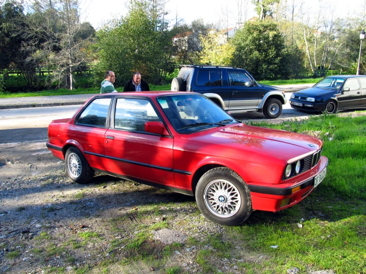 a red bmw in front of the forest