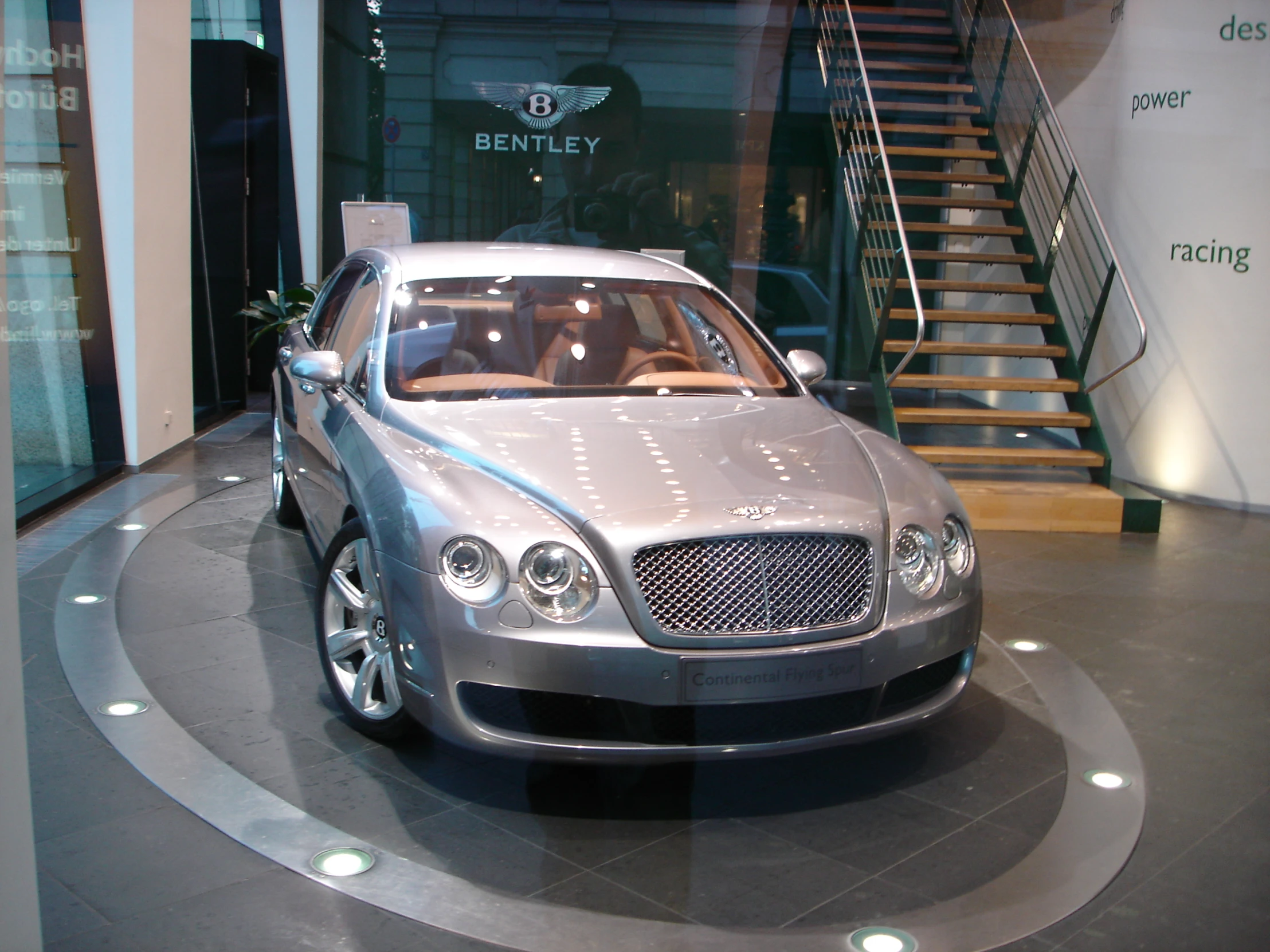 a silver car sitting on display in a showroom