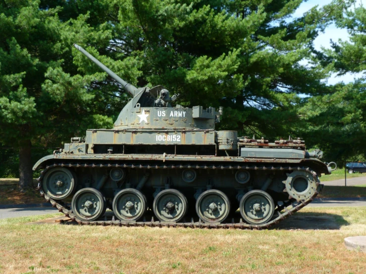 an old army tank sitting on the grass