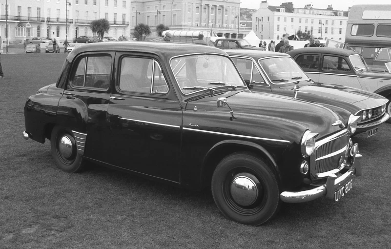 an old car is parked on the grass