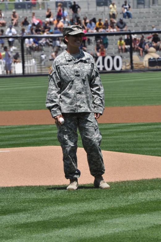 an army soldier standing on top of a baseball field