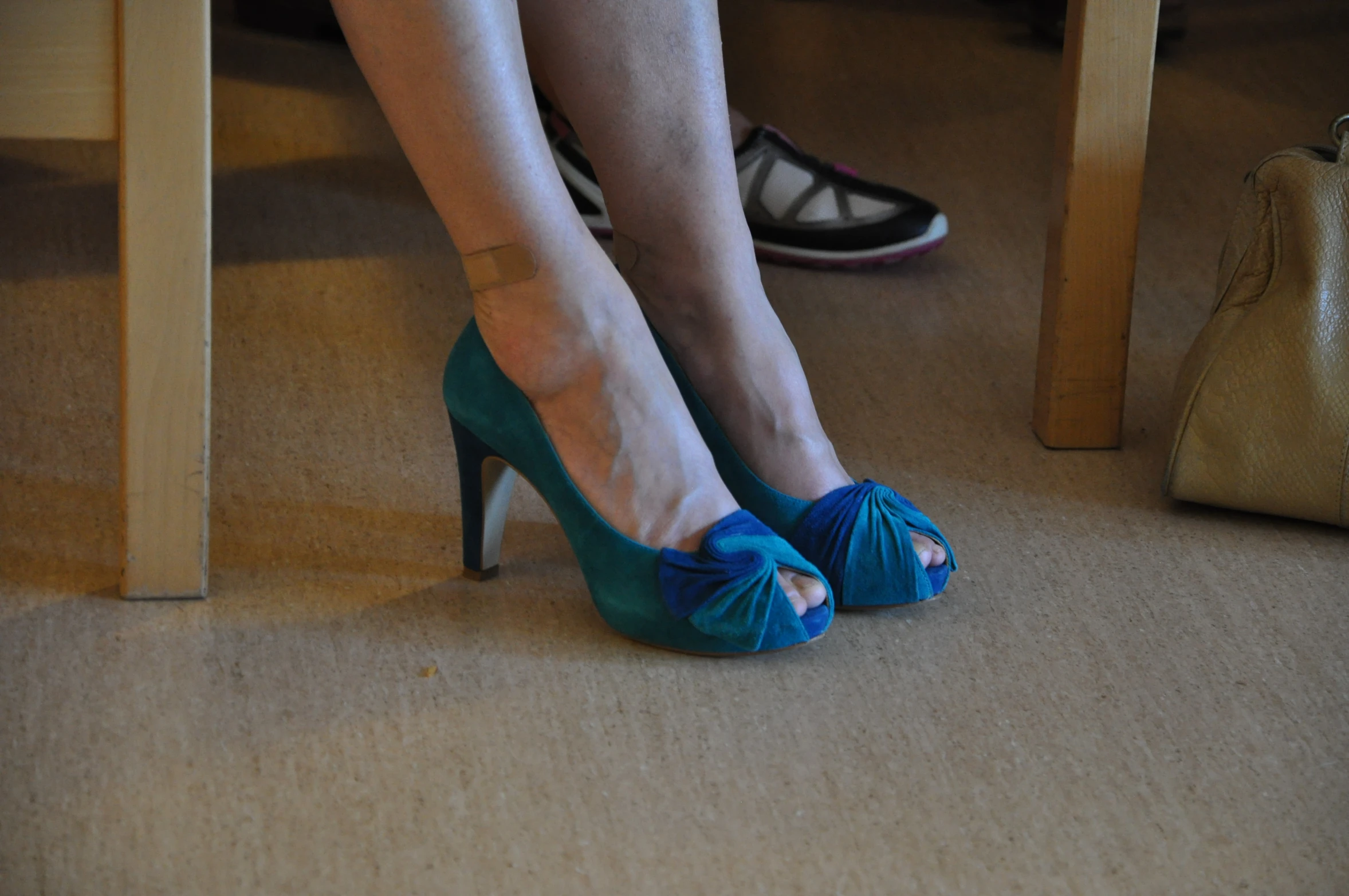 the legs and foot of a woman in blue heels