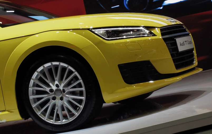 an yellow sports car on display at a show