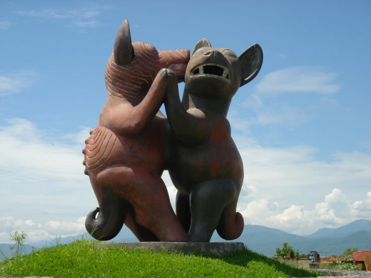 two brown statues of elephants lifting each other