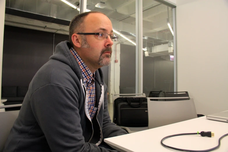 a man sitting at a desk with a laptop