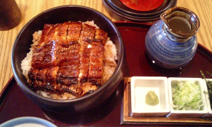 a plate topped with a cut in half pork next to rice and sauce