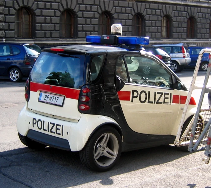 a small white and red police car sitting next to a ladder