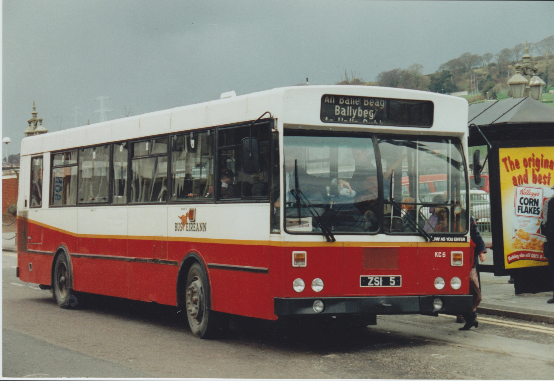 a red and white bus at a bus stop