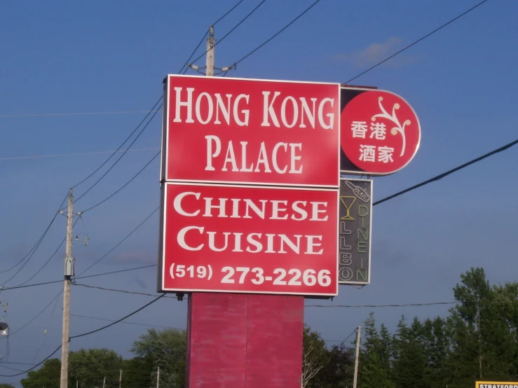 a red sign sits under power lines in the city