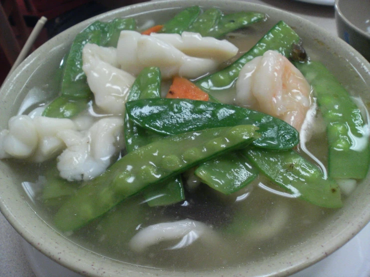 a bowl filled with veggies and dumplings covered in soup