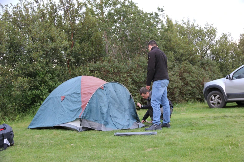 two tents sitting on top of a grass covered field