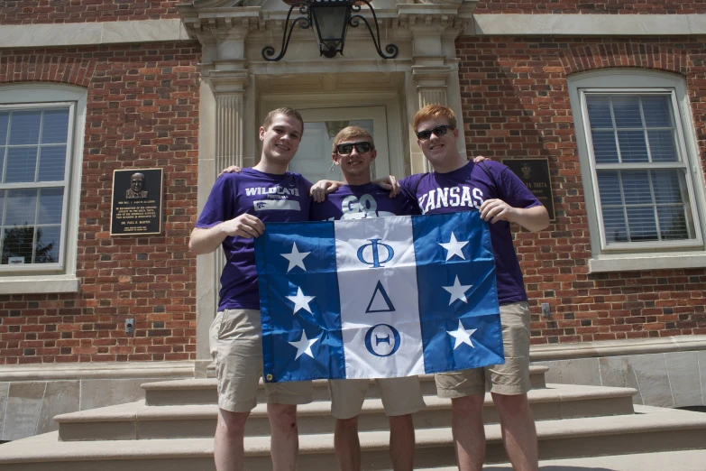 two men standing side by side holding a flag