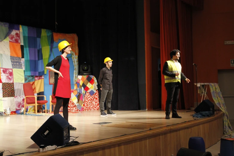 two people are dressed in hard hats on stage