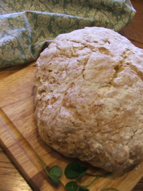 a large fresh biscuit sitting on top of a wooden  board