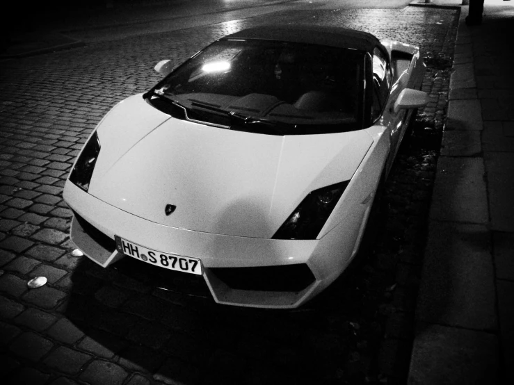 a white sports car is parked on the side of the street