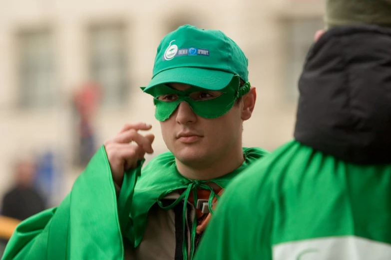 a man wearing a green hat and a green jacket and a green cape