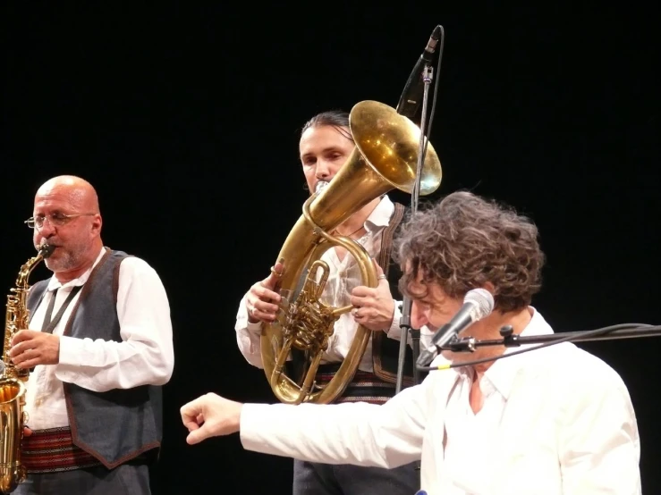 a group of musicians holding instruments up to the side of a stage