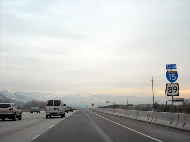 some cars driving on a freeway in the mountains