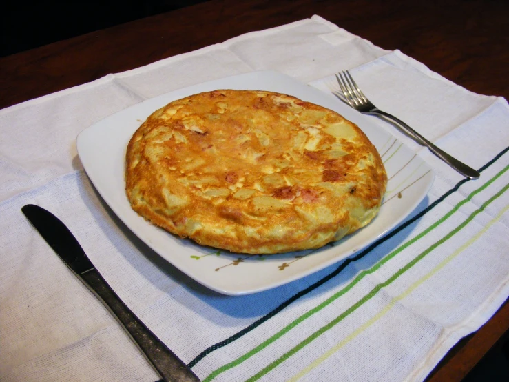 a food entree on a plate with a fork and knife