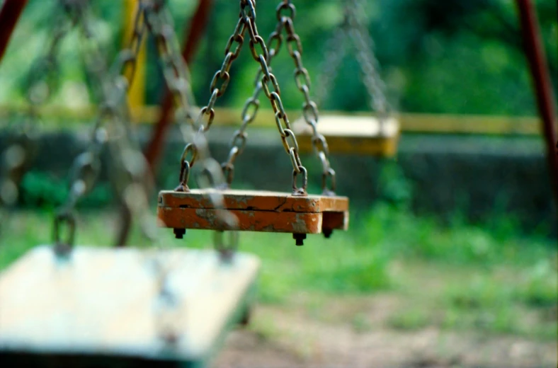 a swing set has two swings and chains attached to it