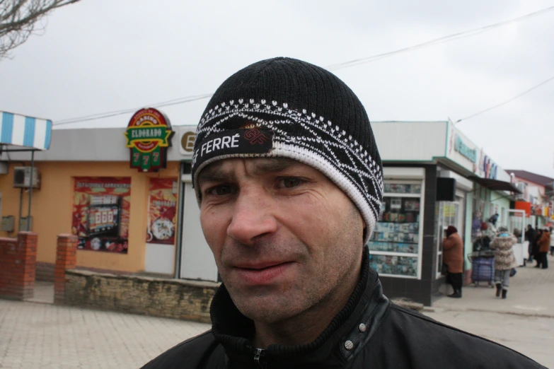 a man with a beanie on posing for a po in the street