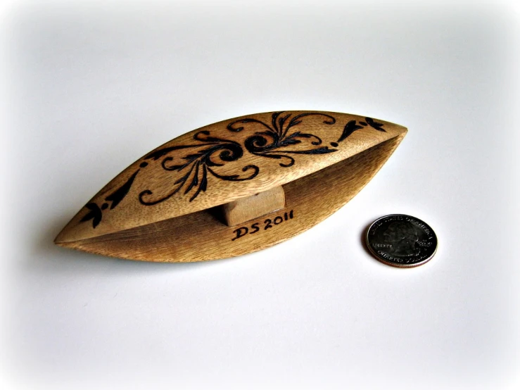 a small wooden plane shaped object with a penny underneath