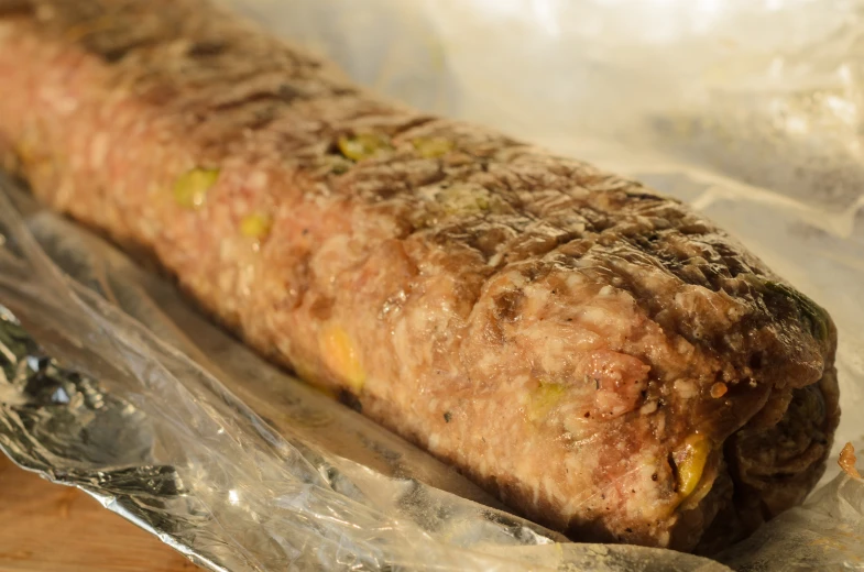 a meat covered piece of food on top of foil