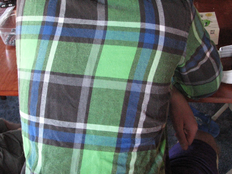 a person in a plaid shirt next to a remote
