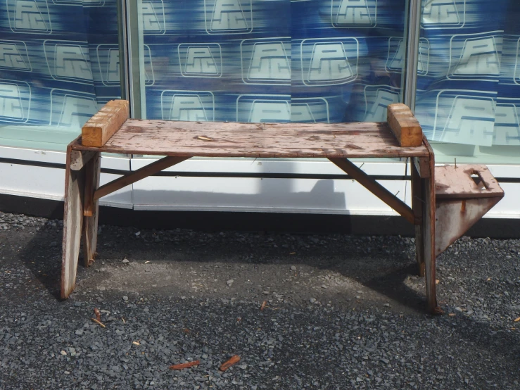 a wooden bench sits next to a glass wall