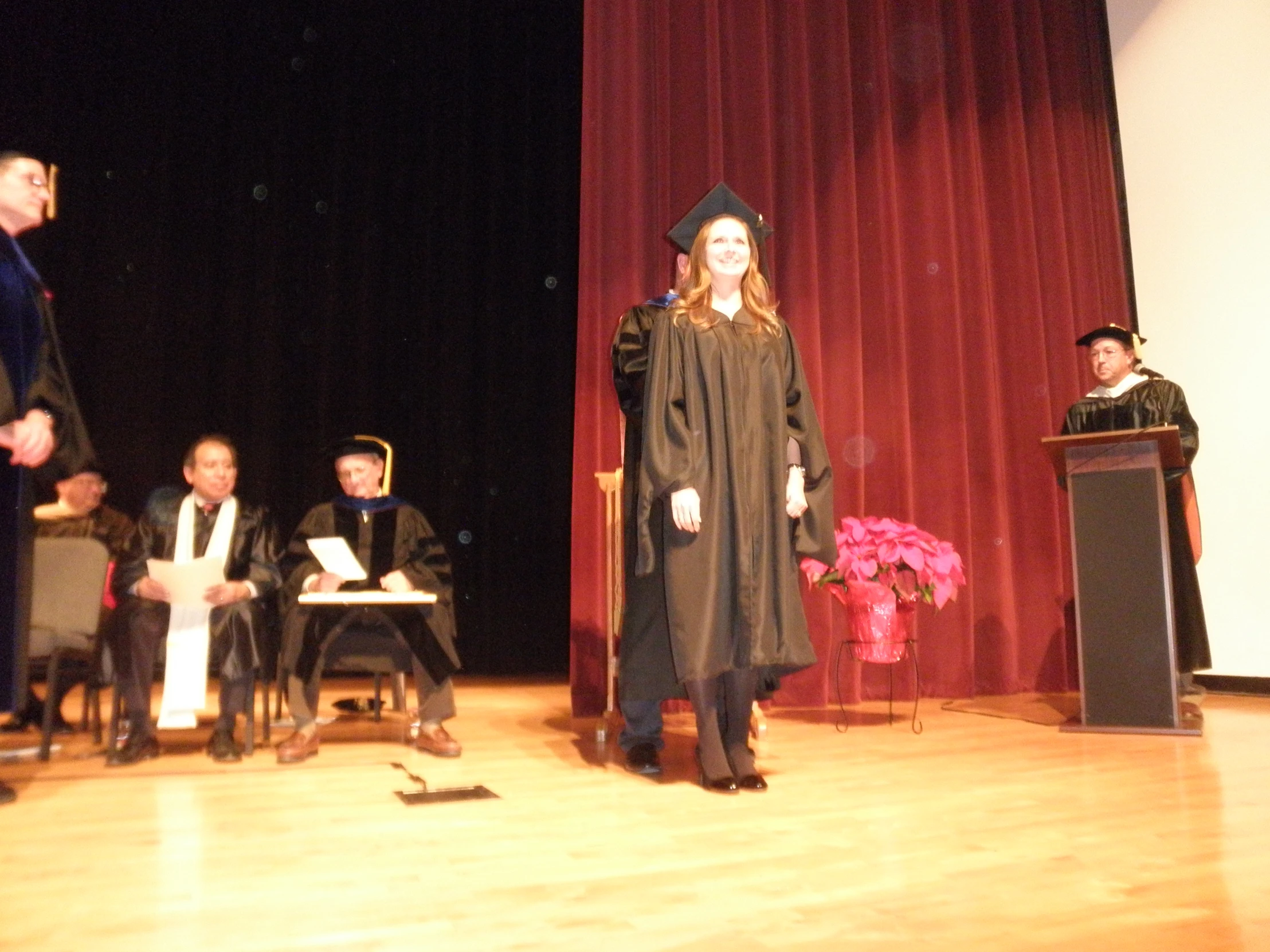 a person standing at a podium wearing a gown