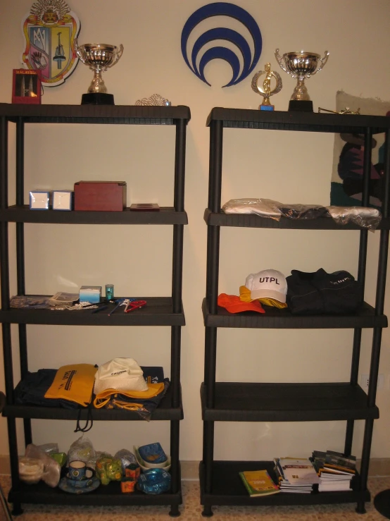 two black bookcases are full of stuff and trophy cups