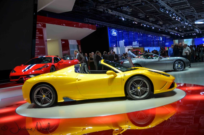 a yellow sports car sits on a show floor