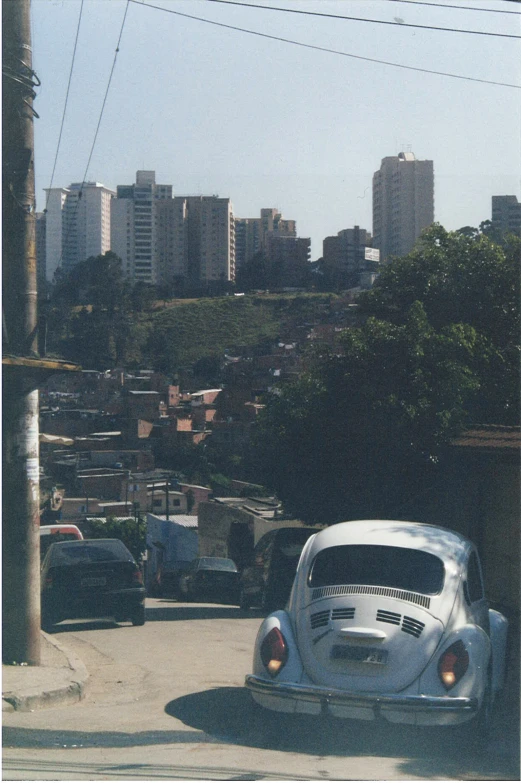 a white car parked in the street next to a pole