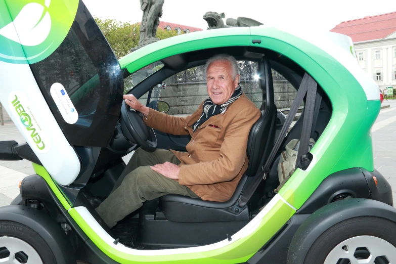 a man sitting in the drivers seat of a small car