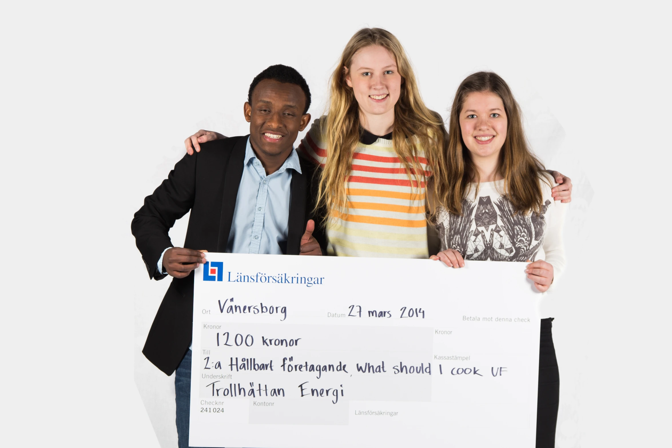 three teenage girls and one boy pose for a po holding a large cheque