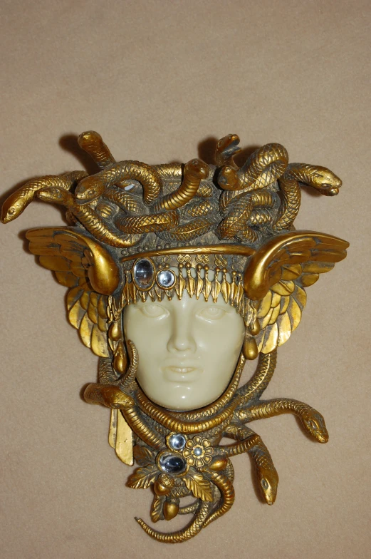 an intricate headpiece is adorned with beads and snake's heads