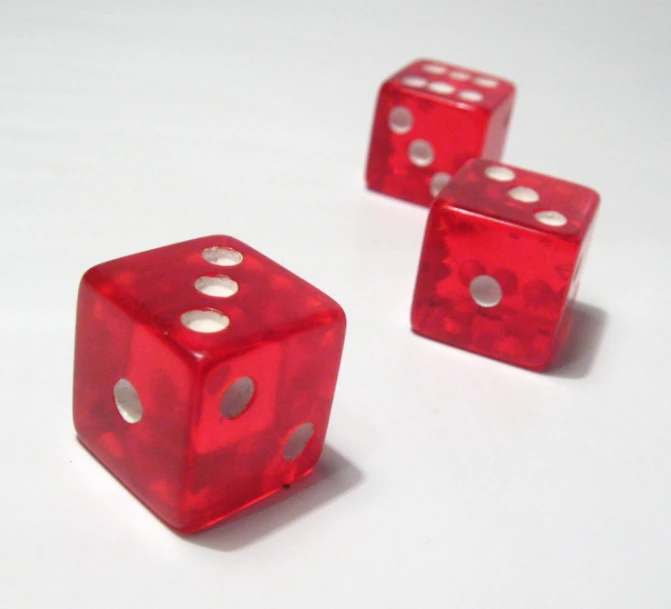 three red dices with holes on them laying down