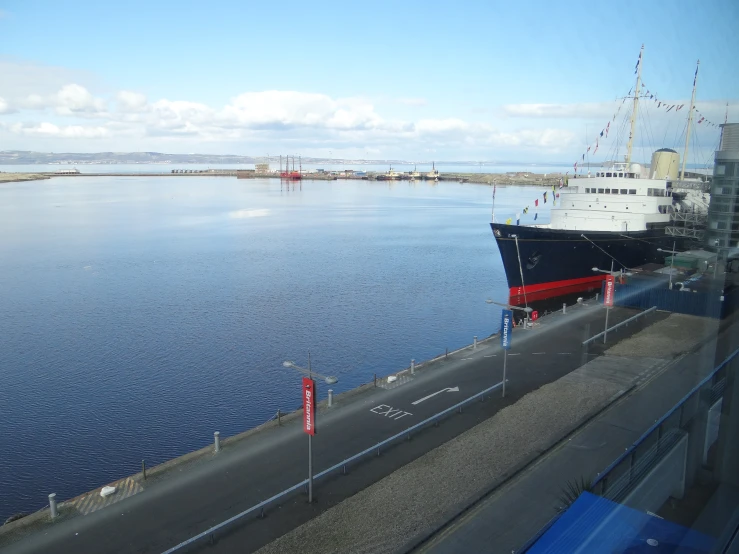 an empty road running alongside a large body of water