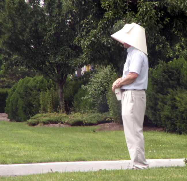 a man with a large, large sunhat on and one hand in his pocket