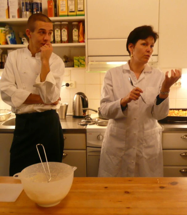 two people in a kitchen next to a counter