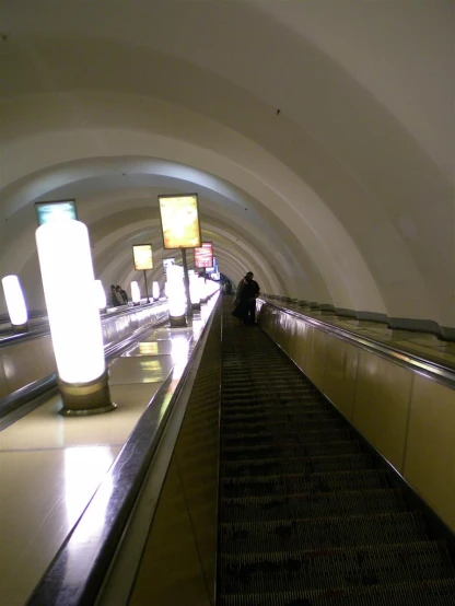 a group of people riding an escalator down a hill