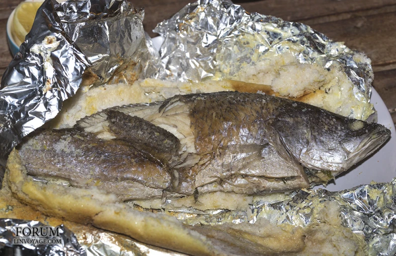a fish is placed next to foil on a table
