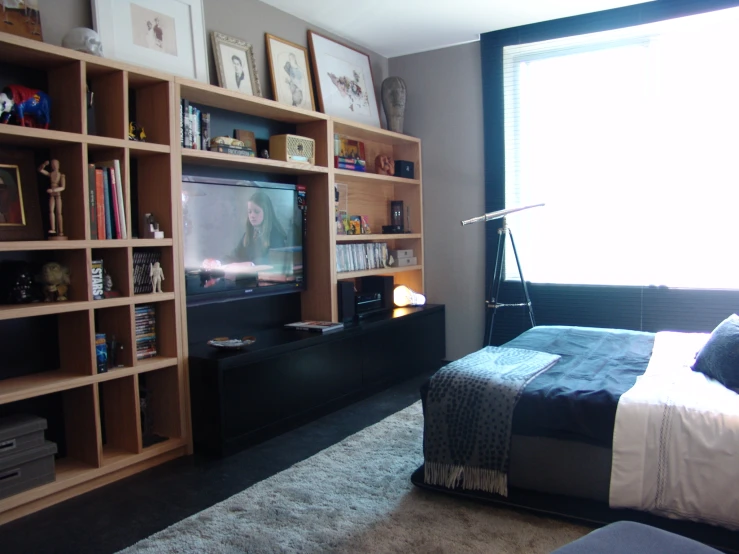 a living room with a large television and shelves