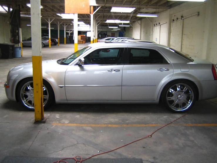 a silver car parked in a garage next to a pole