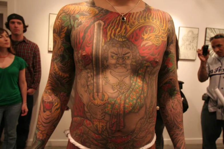 a man has a lot of tattoos on his body