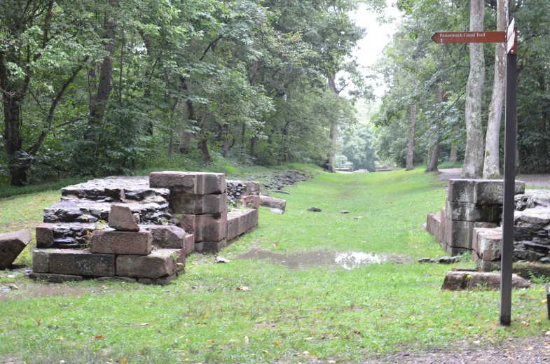 a road surrounded by some rocks in a green field