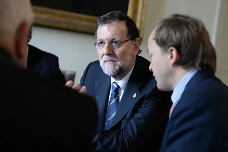 a group of men sitting around each other having conversation