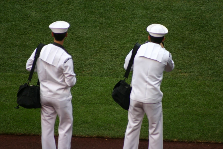 two people in white uniforms walking side by side