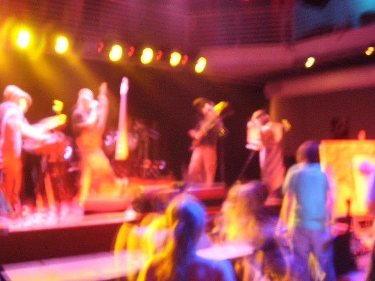 people standing on stage on bright colored lighting